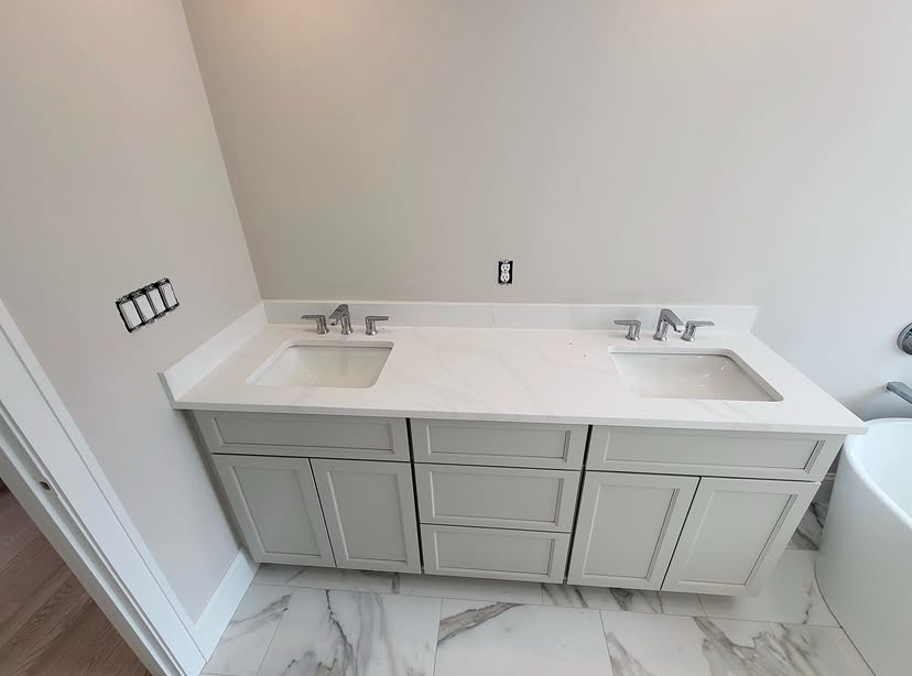 Double vanity with two undermount sinks, quartz countertop and new chrome faucets in a finished bathroom